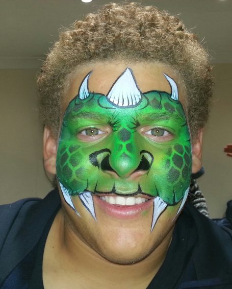 Green dinosaur face painted by Hazel